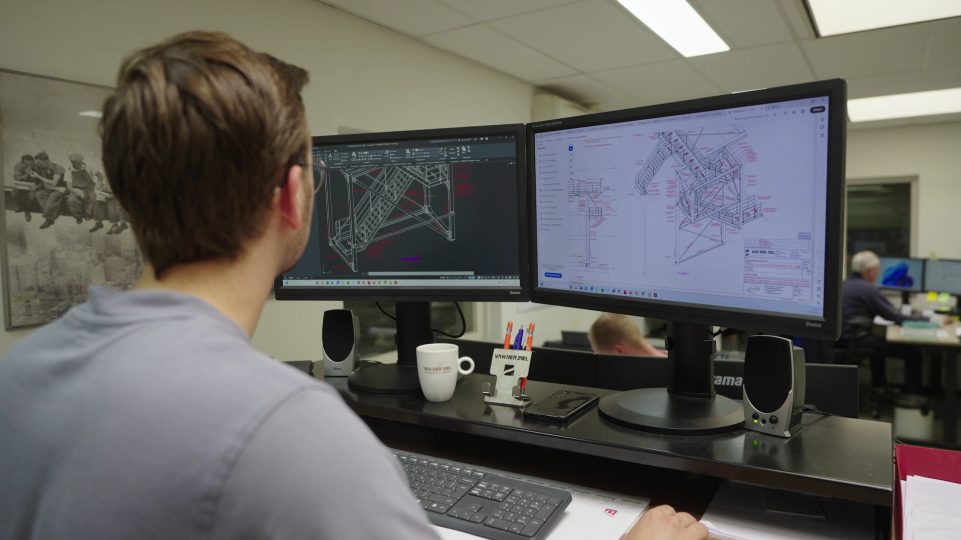 Engineer van Van der Ziel werkt op twee schermen aan een 3D-tekening van een stalen trap